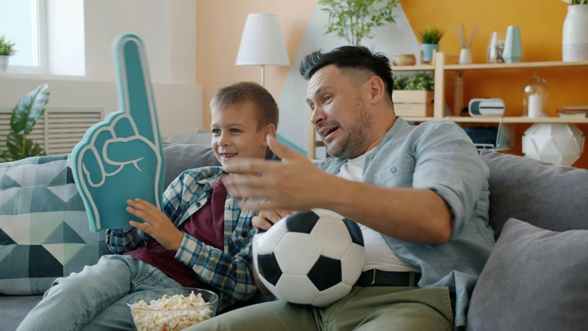 dad watching sports with son