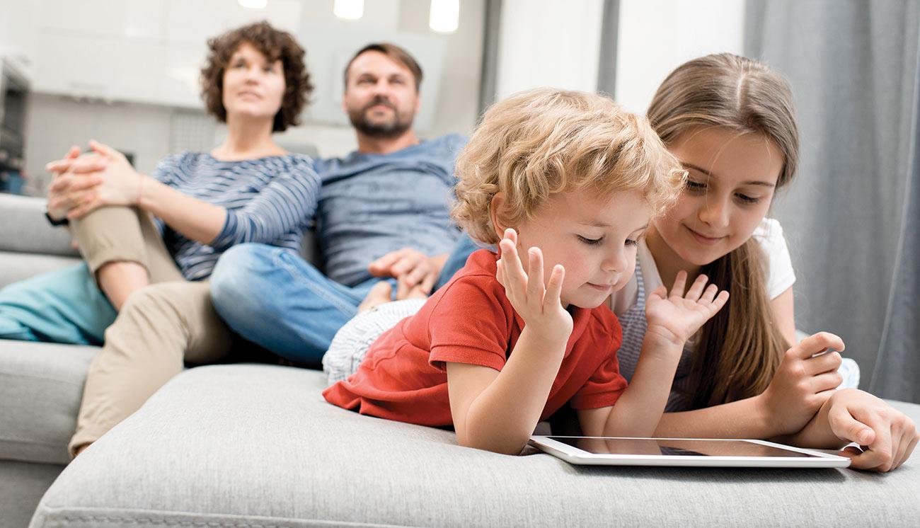 family streaming content together in family room on tv and tablet